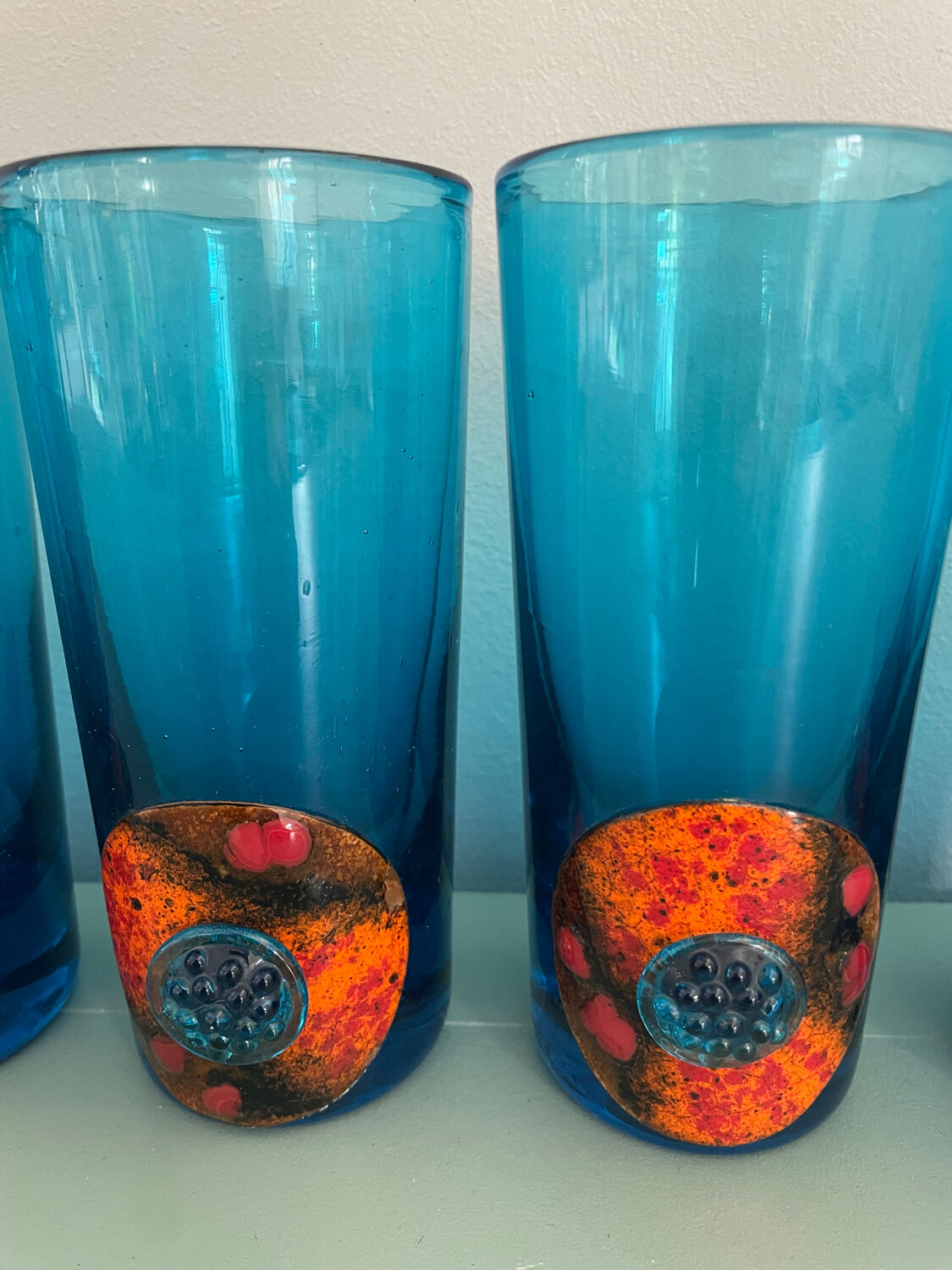 Six blue blown glass and enamel on copper glasses.