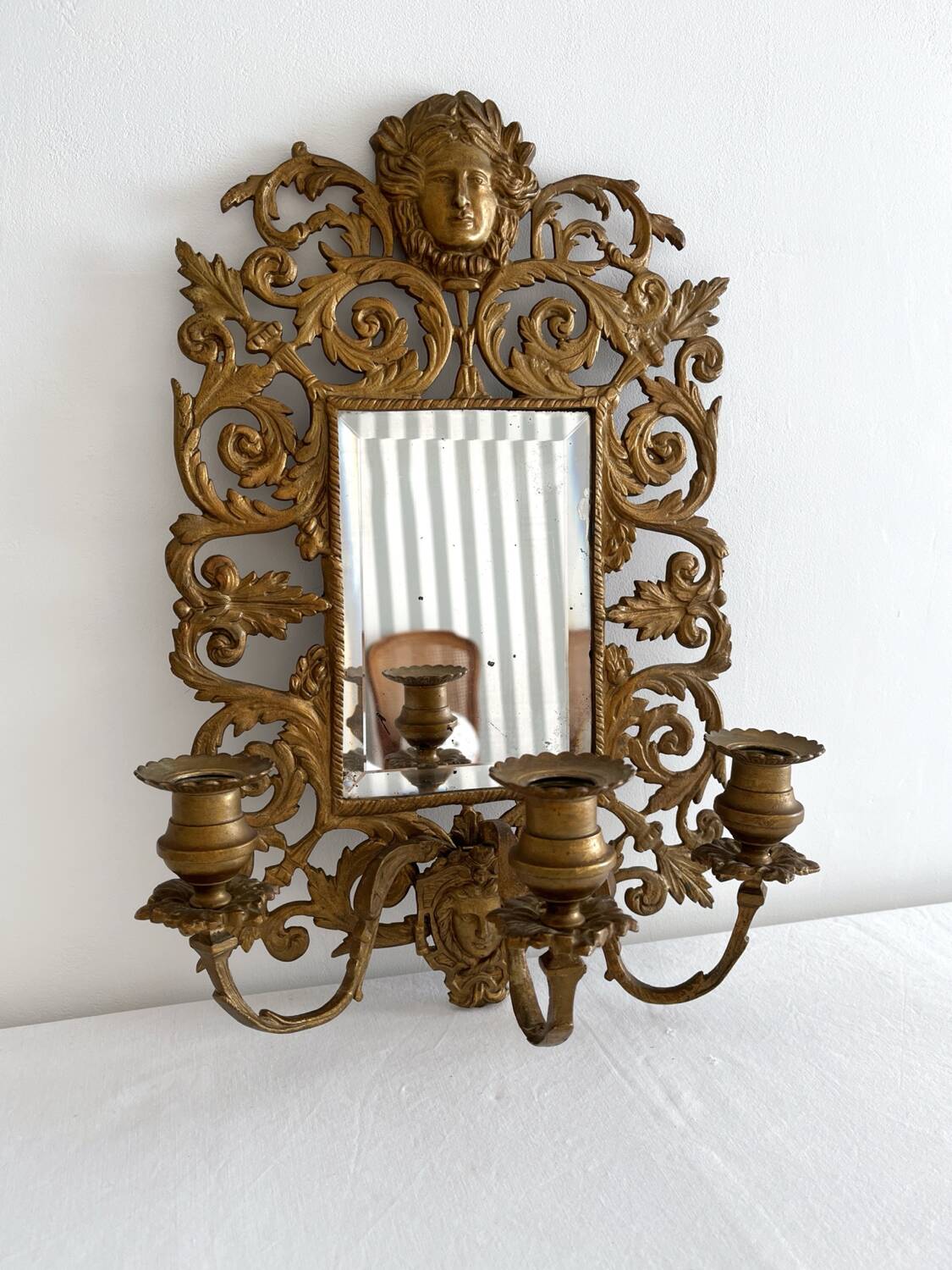 Bevelled mirror wall sconce in gilded bronze with 3 candle holders.