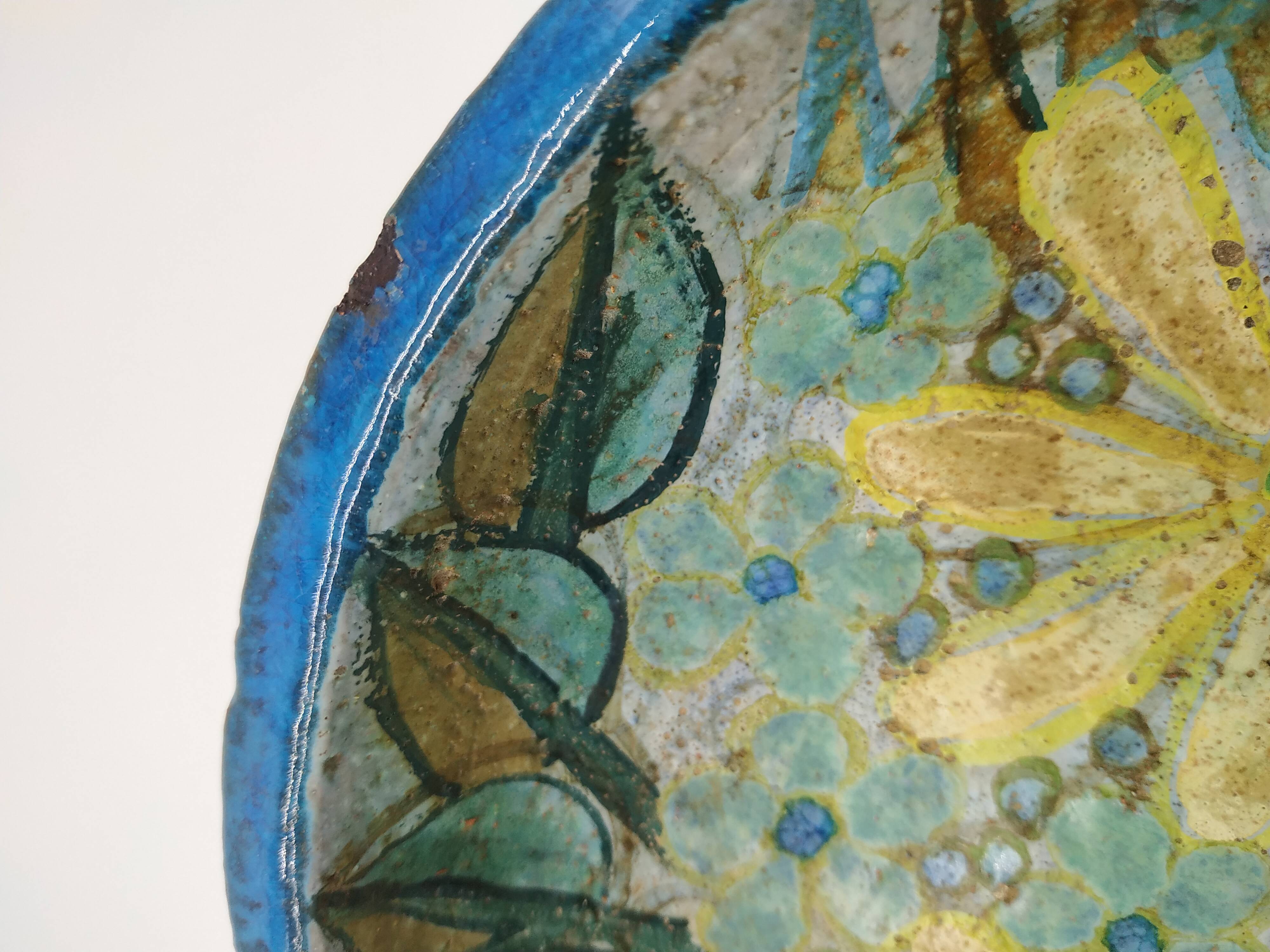 Hollow cut in blue enamelled sandstone decorated with yellow flowers