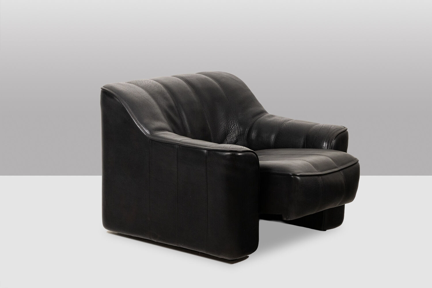 Maison De Sede. Armchair and its ottoman in black leather. 1970s.