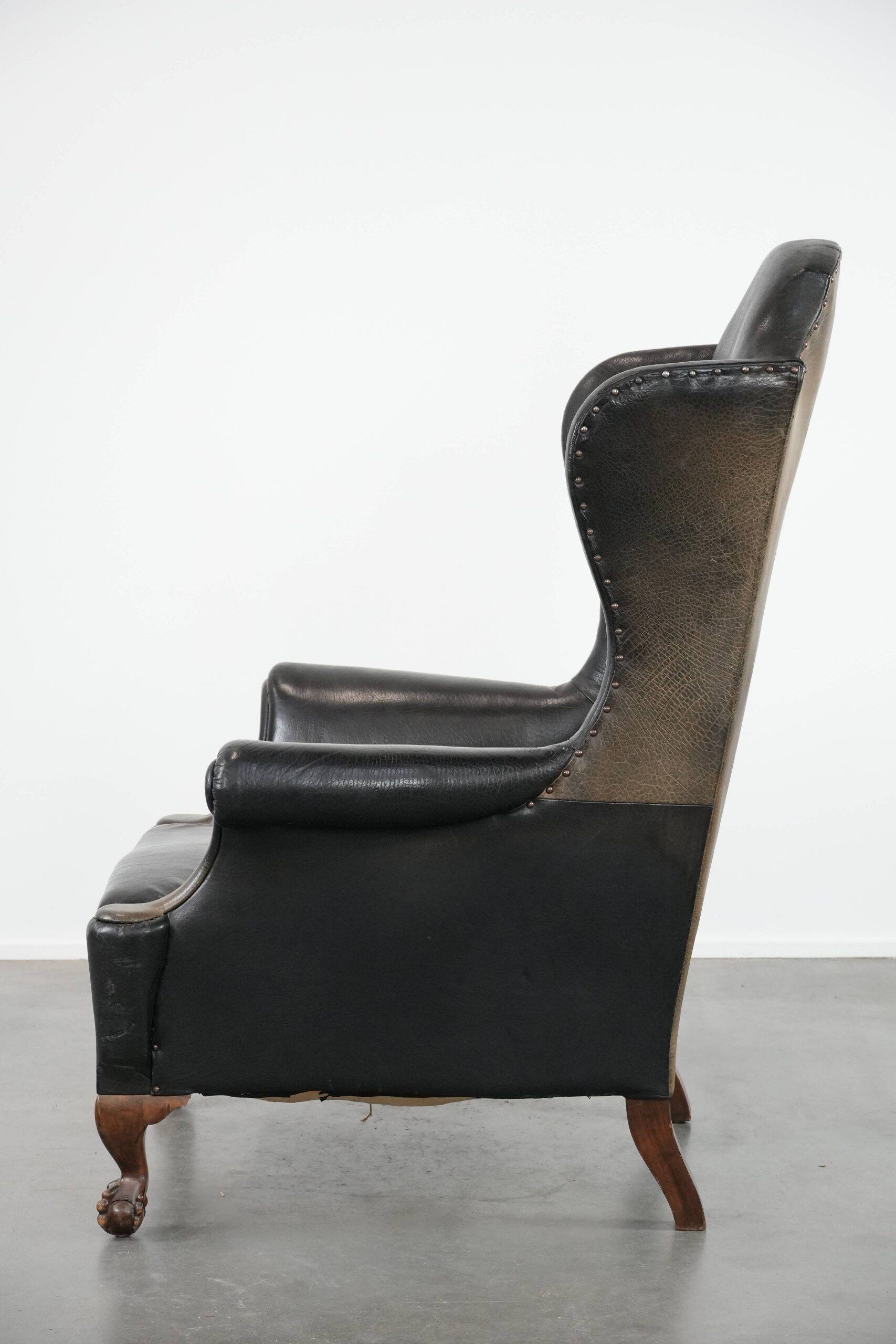 Antique black English cow leather wingback armchair from the 19th century