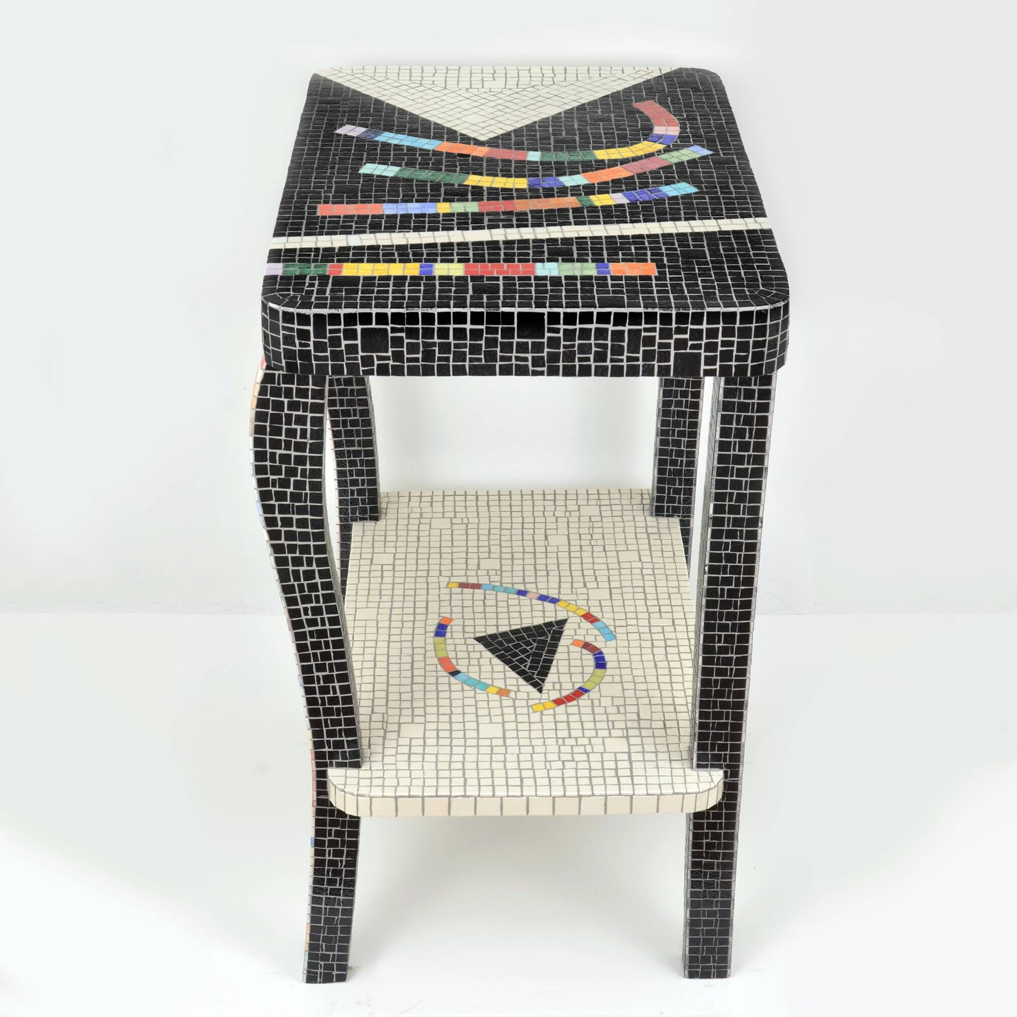 Table topped with a ceramic mosaic featuring an abstract design.