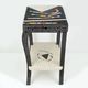 Table topped with a ceramic mosaic featuring an abstract design.