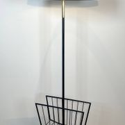 Designer floor lamp in black lacquered metal and brass, incorporating a magazine rack