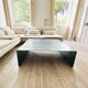 Coffee table with raw metal steel leaf.