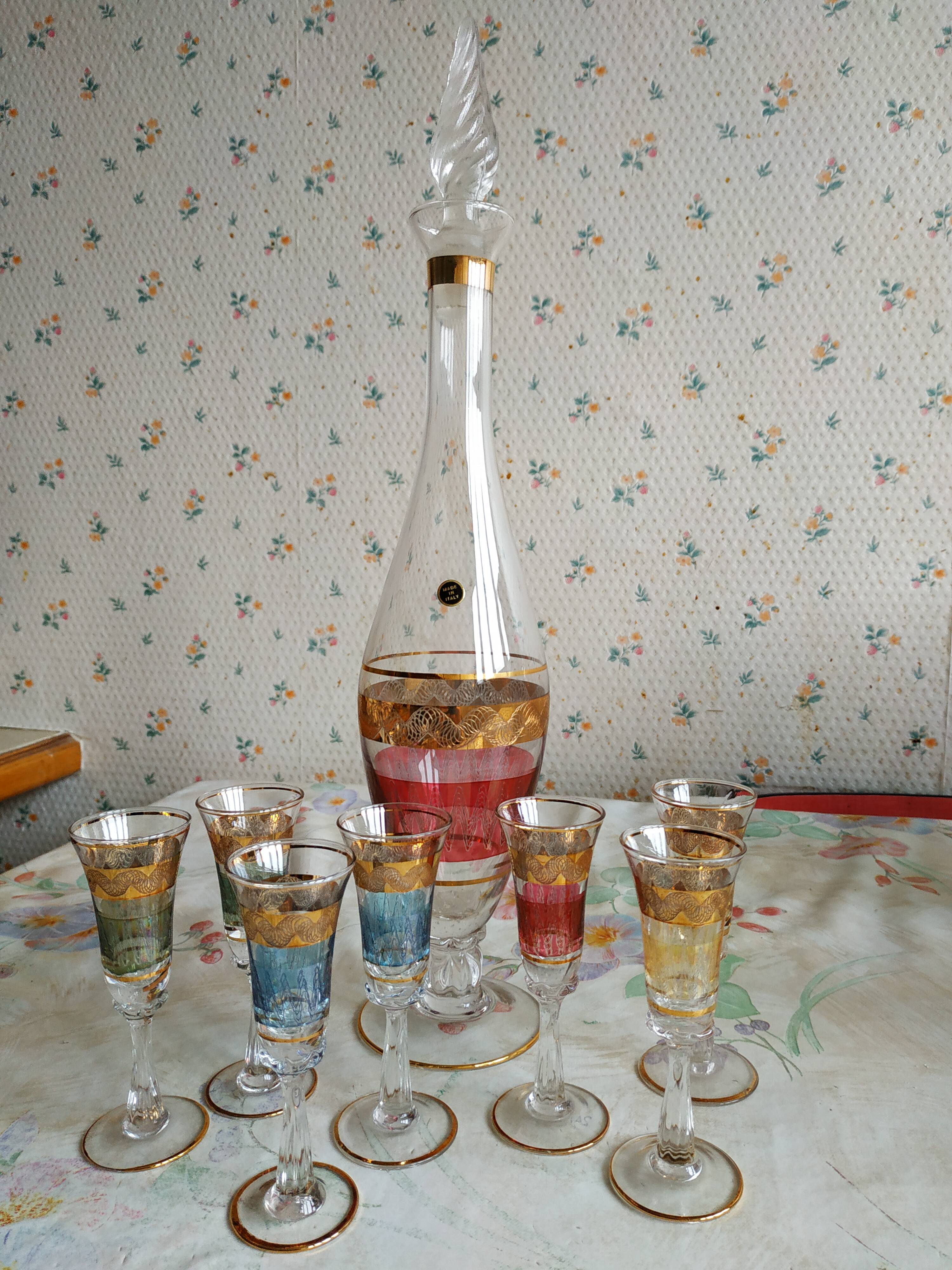 Liqueur set, colored and golden glasses and carafe