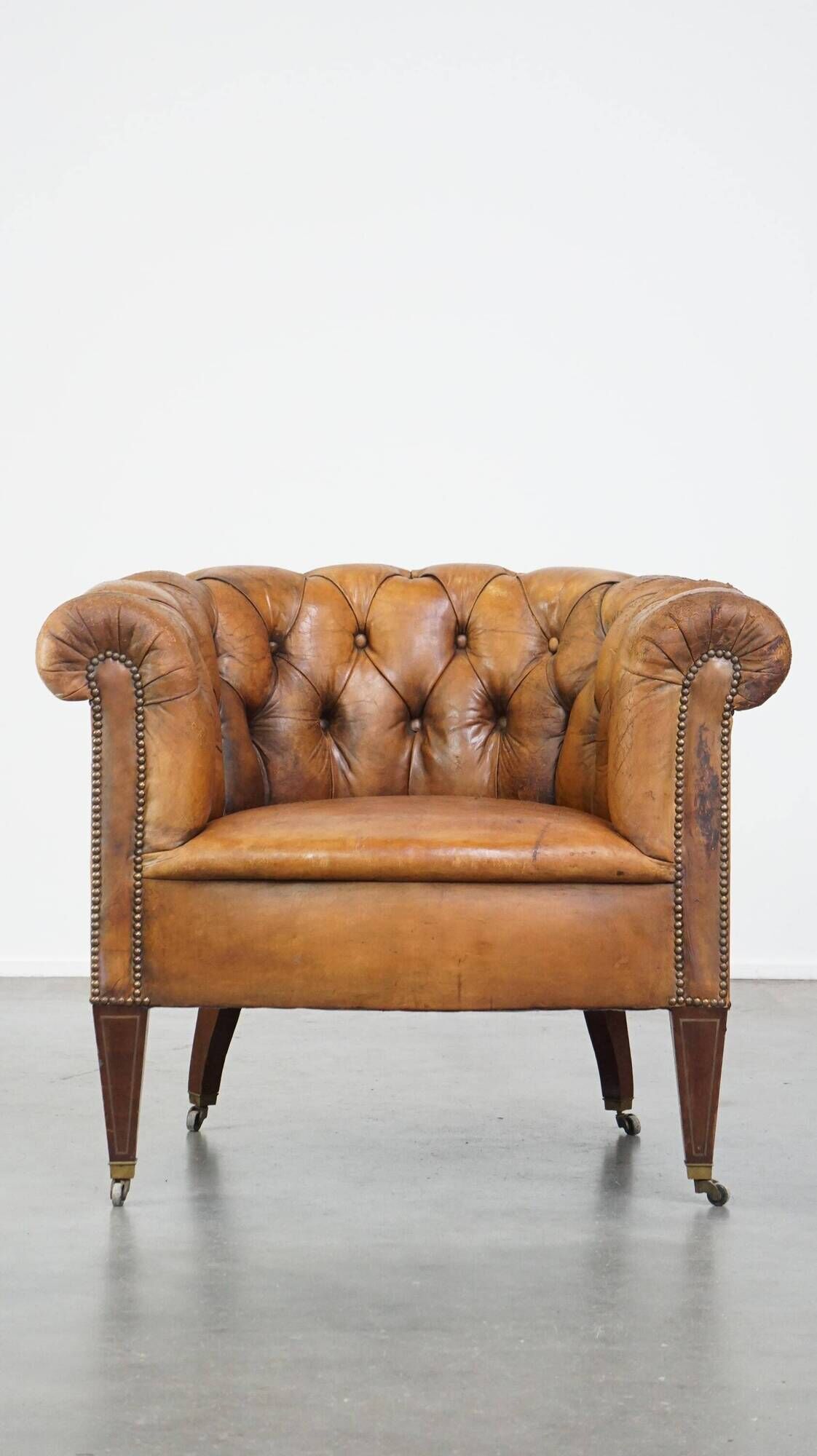 Antique, characteristic sheepskin chesterfield club chair on wheels
