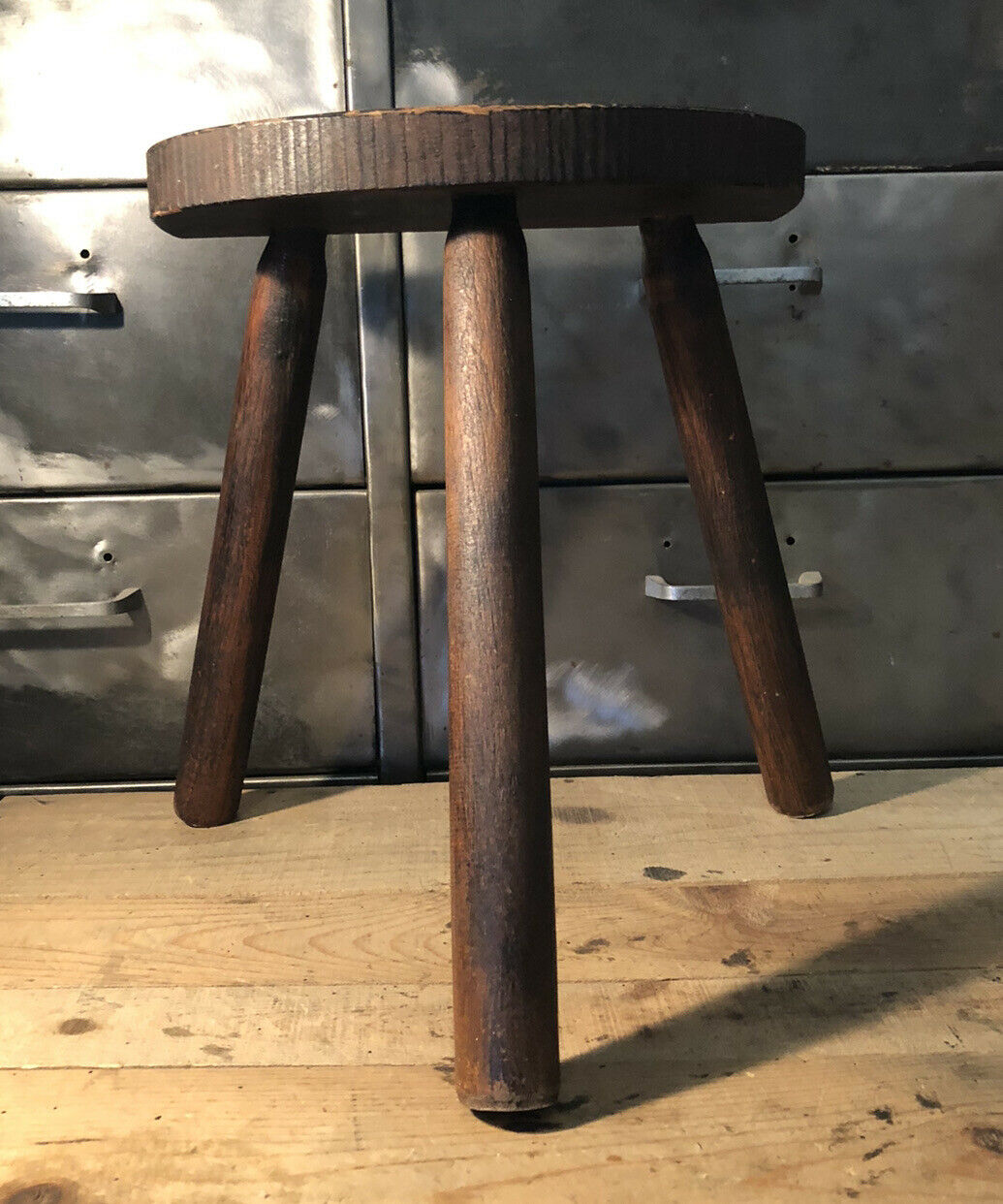 Wooden milking stool on tripod base