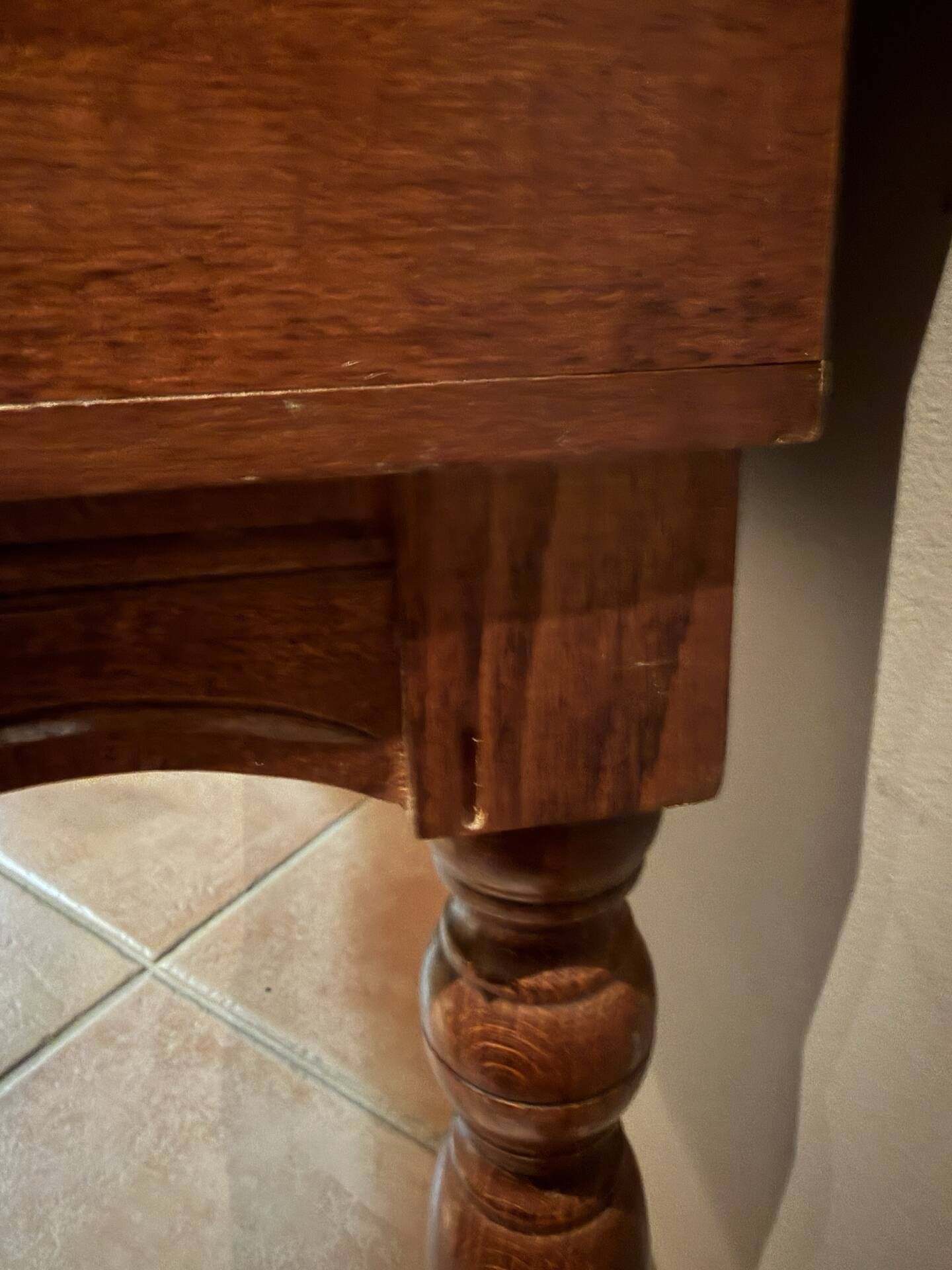 Antique carved wooden bench with green upholstered seat and backrest.