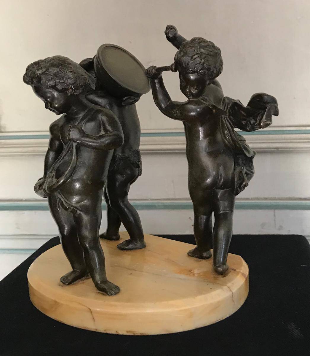 Three musician angels, bronze sculptures on a marble base.