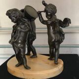 Three musician angels, bronze sculptures on a marble base.