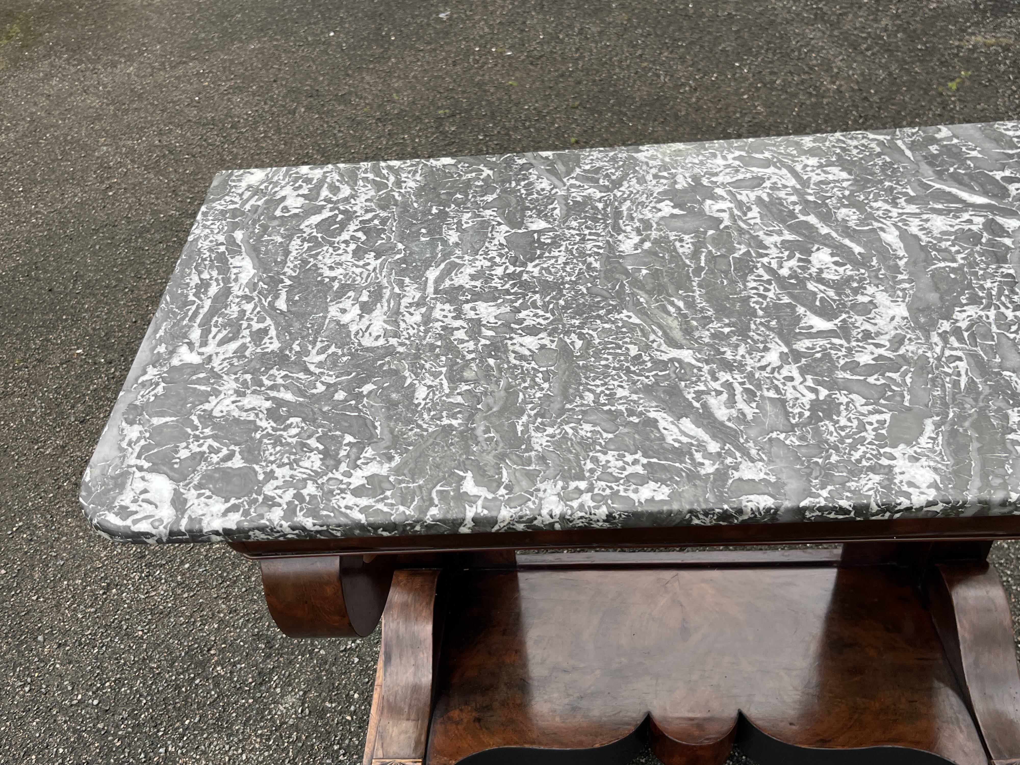 Mahogany console with grey marble top and lion paw feet.