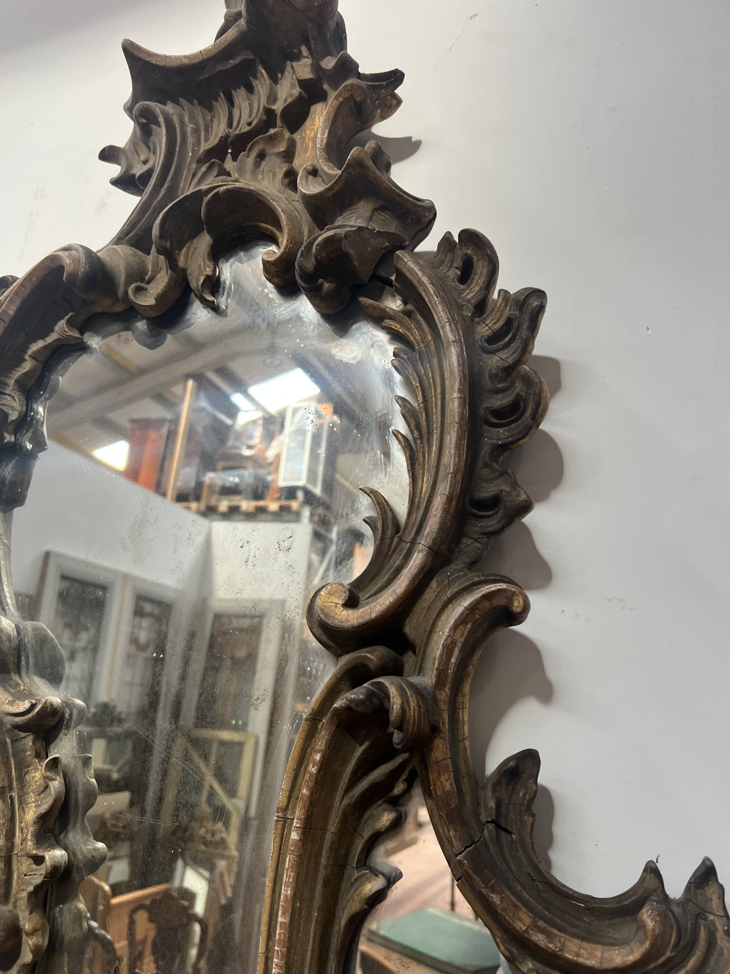 Mirror with a decorative frame featuring a four-light wall sconce, 19th century.