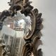 Mirror with a decorative frame featuring a four-light wall sconce, 19th century.