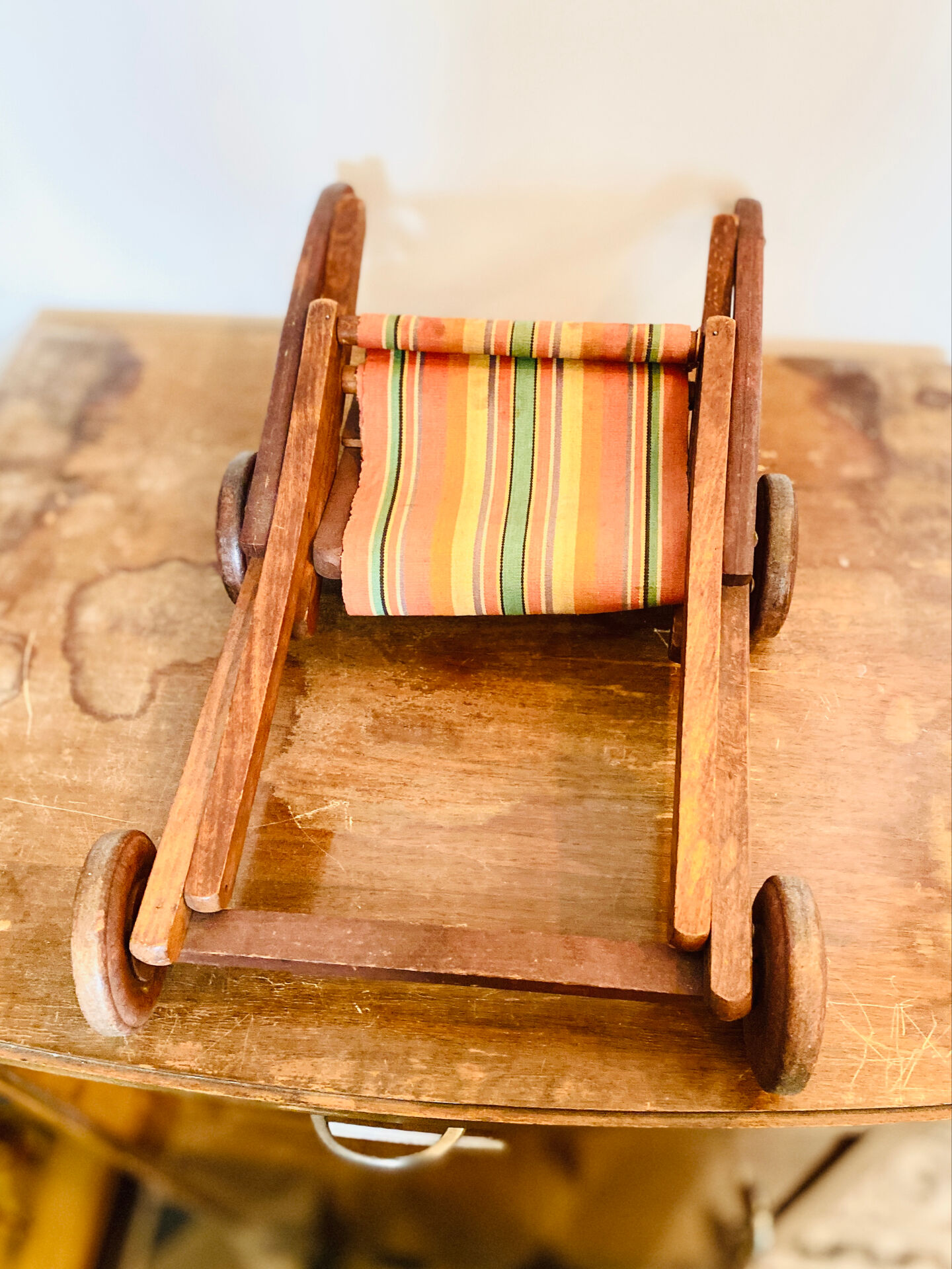 Vintage wooden folding doll's deckchair on wheels