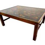 Table basse en bois exotique, garniture laiton et planisphère sous verre.