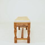 Vintage oak bench with striped linen fabric in a country style.