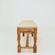 Vintage oak bench with striped linen fabric in a country style.