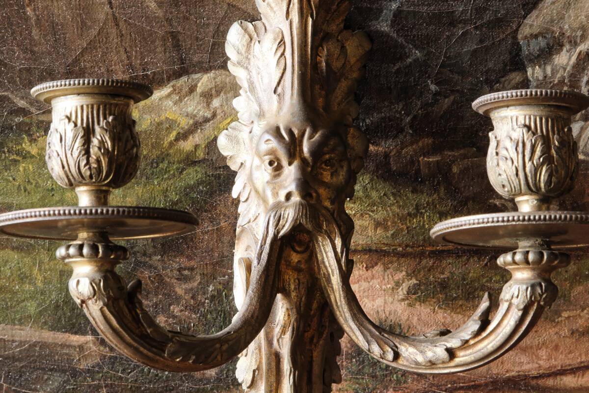Monobloc gilded bronze wall light, grotesque satyr, two lights.