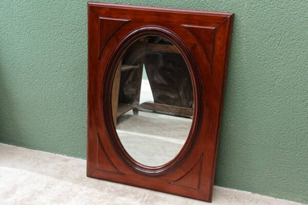 Miroir ovale en verre biseauté et acajou massif