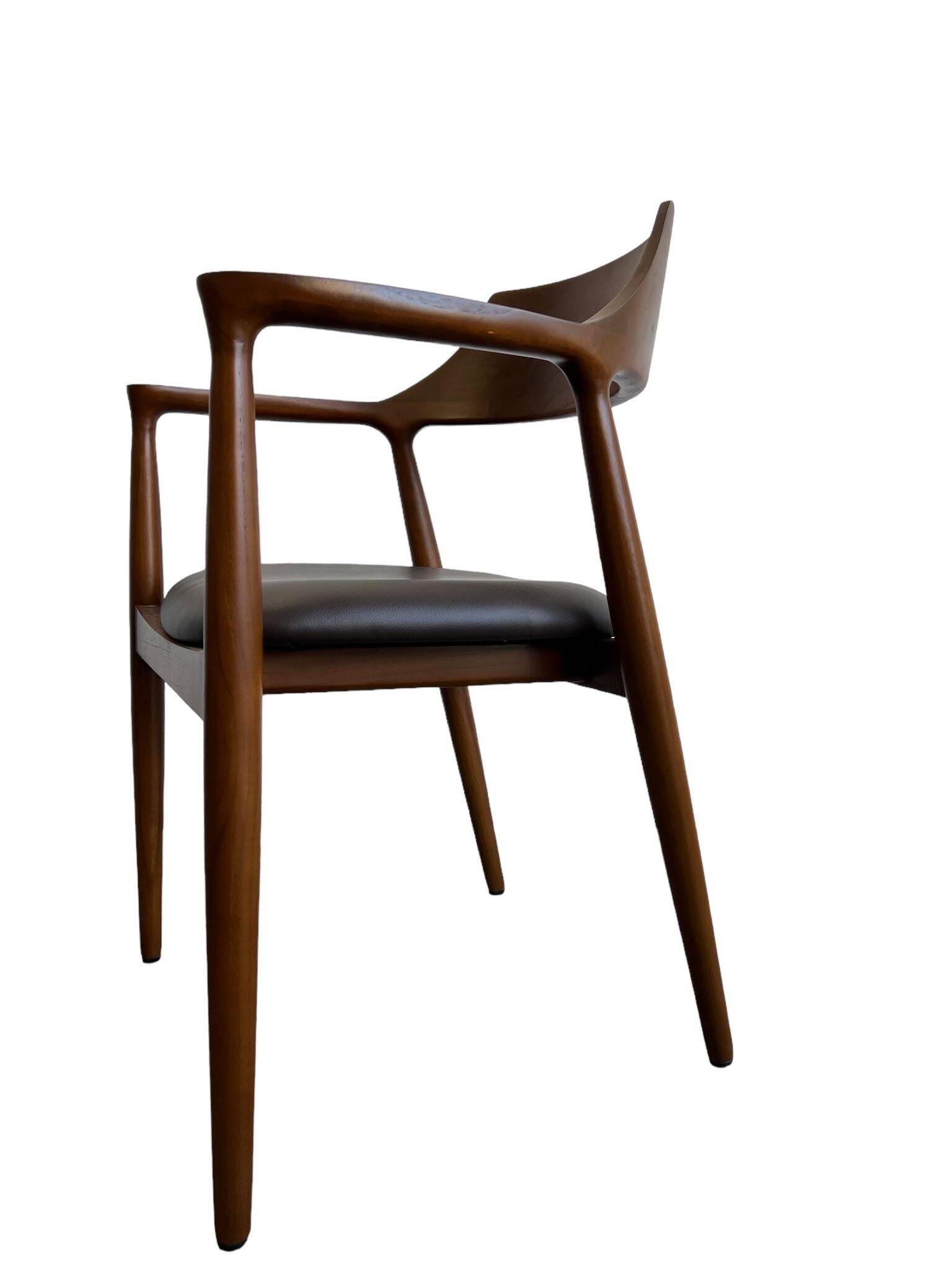 Curved wooden dining chair with brown leather seat