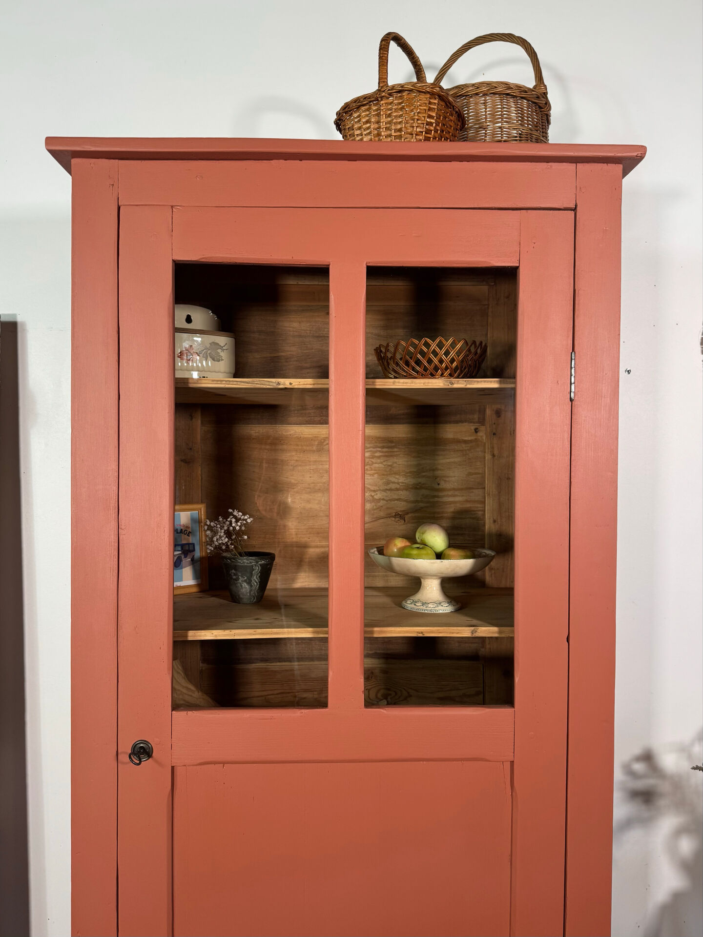 Antique glass-fronted terracotta cupboard