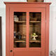 Antique glass-fronted terracotta cupboard
