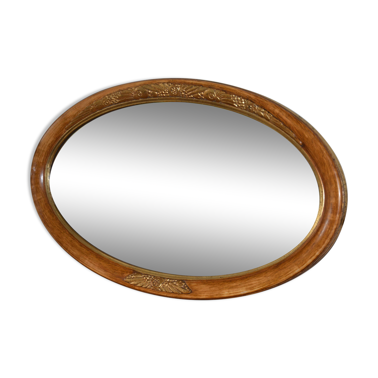 Old oval beveled wooden mirror, partly gilded and carved