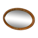 Old oval beveled wooden mirror, partly gilded and carved