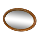 Old oval beveled wooden mirror, partly gilded and carved