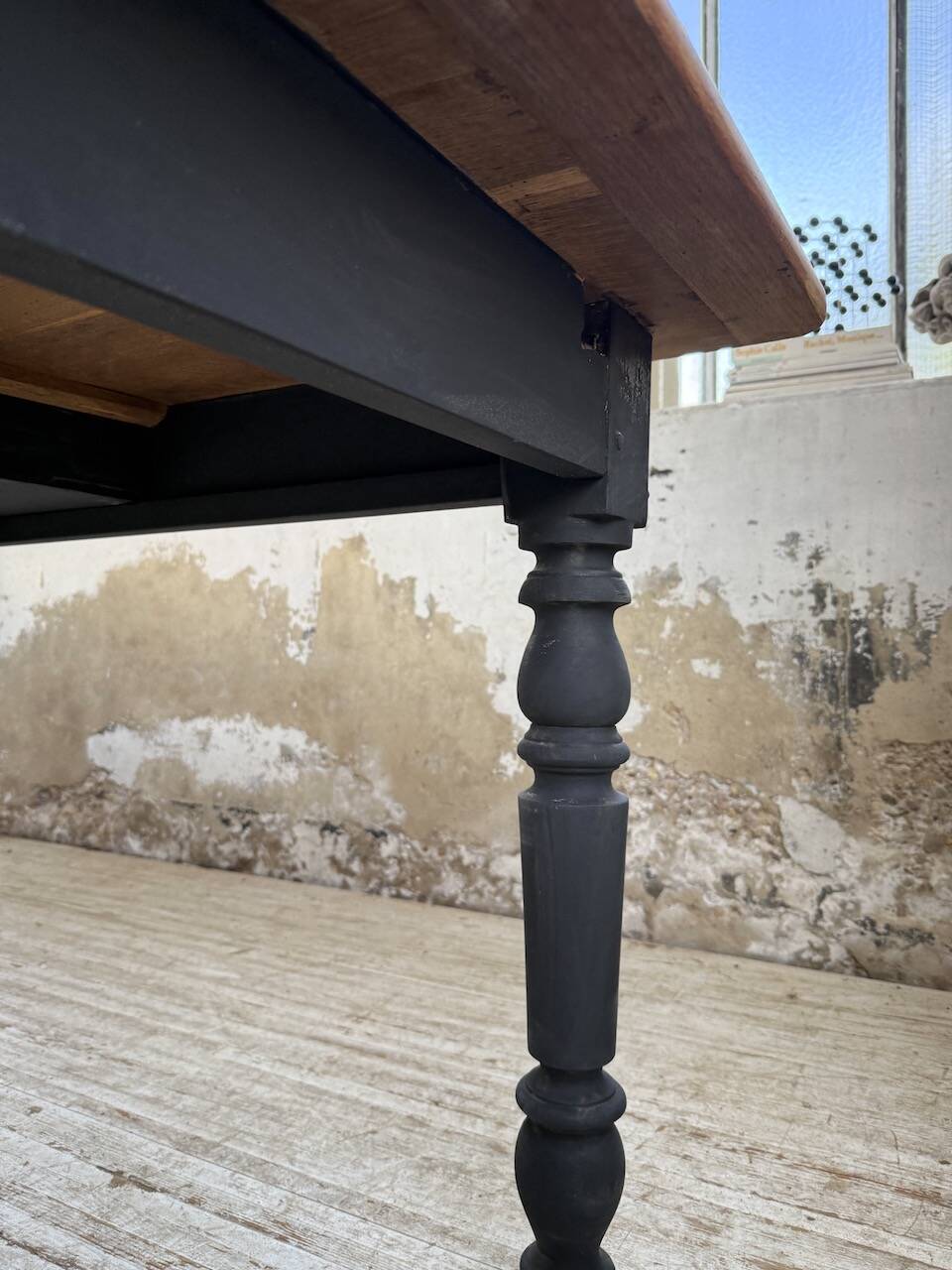 Oak farmhouse table with turned black legs.