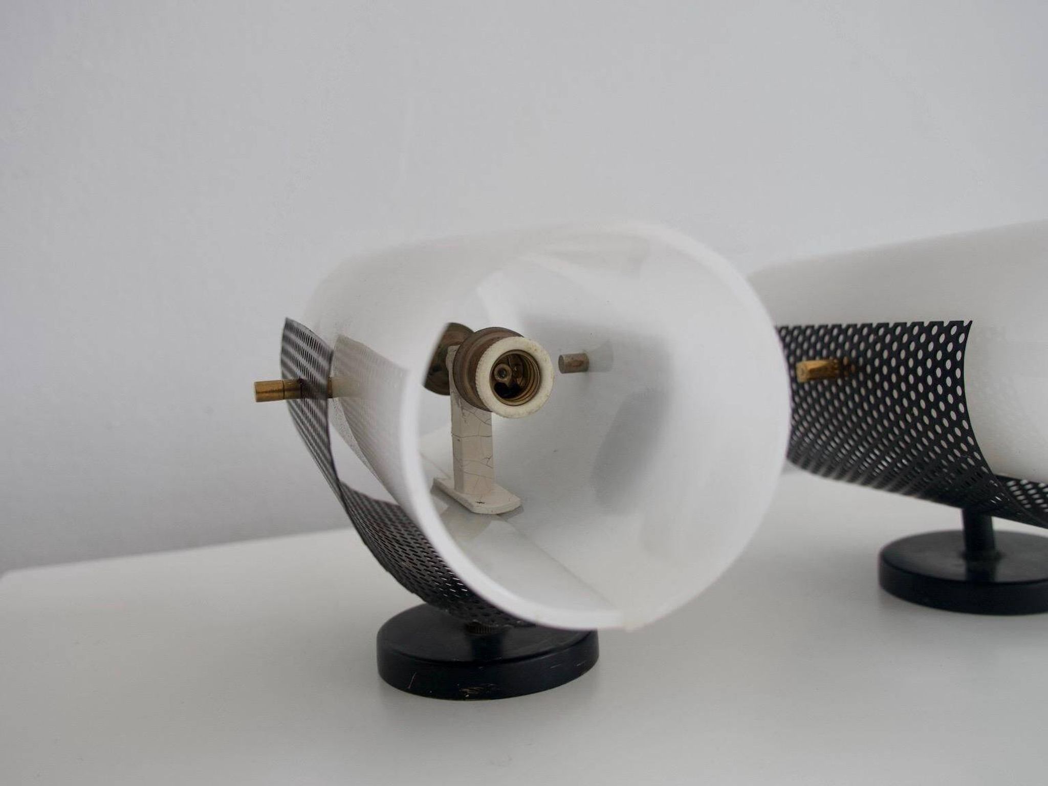 Set of four wall lights in white plexiglass and perforated black metal.