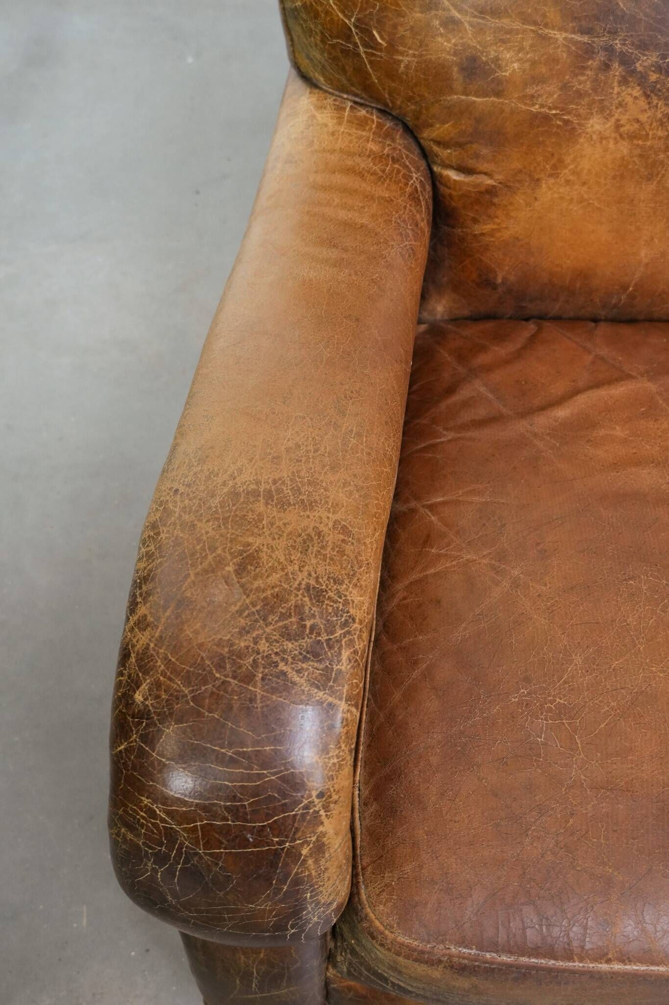 Charming and comfortable vintage armchair in grained cowhide leather with character