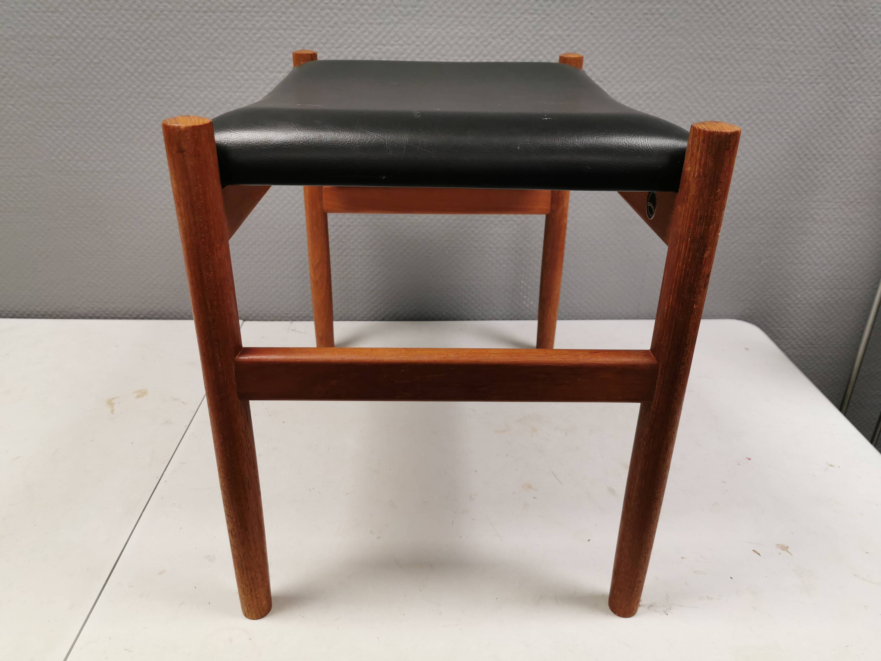 Danish designed footstool in teak wood and black skai “imitation leather”