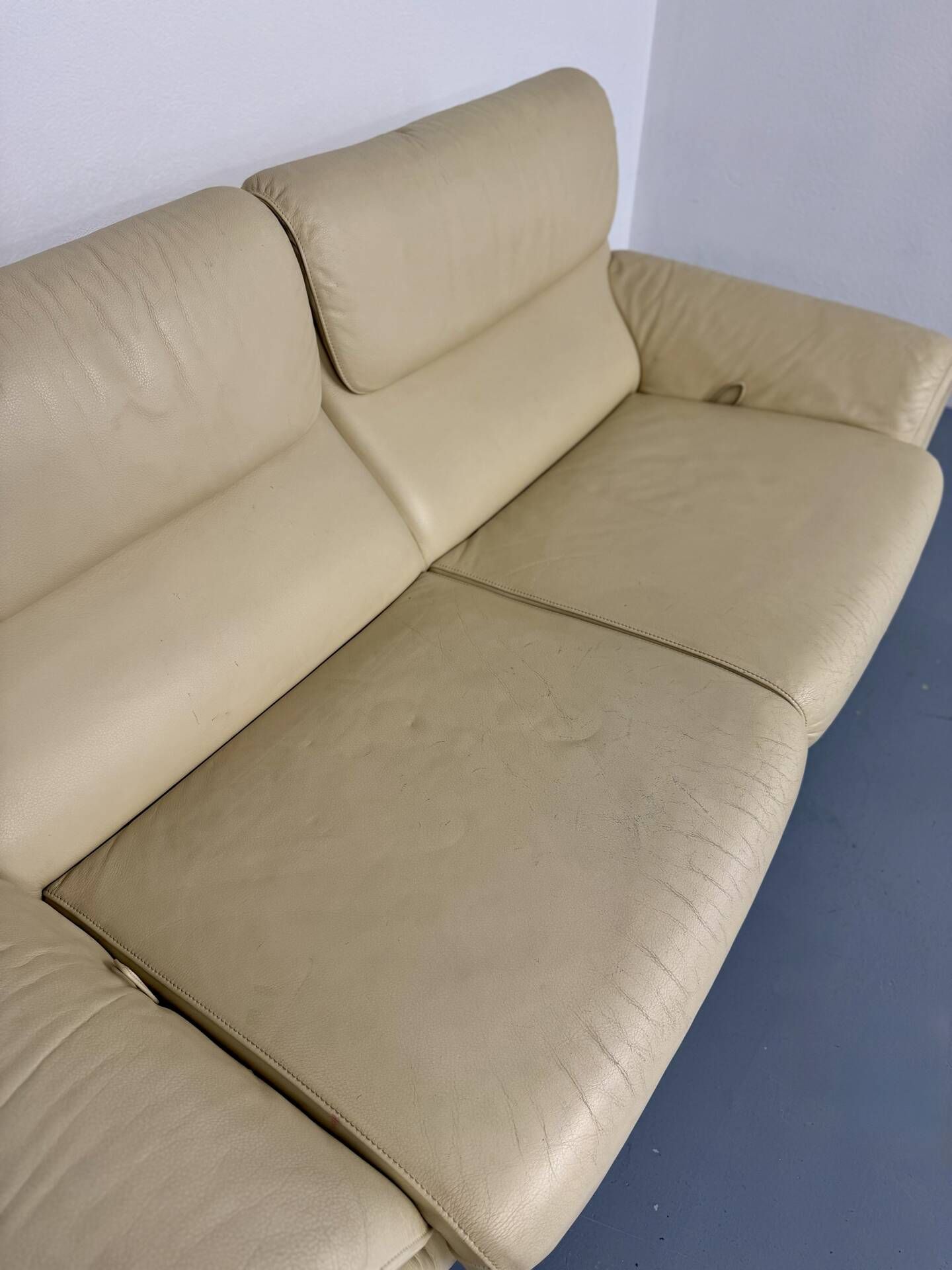 Two-seater designer sofa De Sede DS-2011 in cream leather with adjustable backrest.