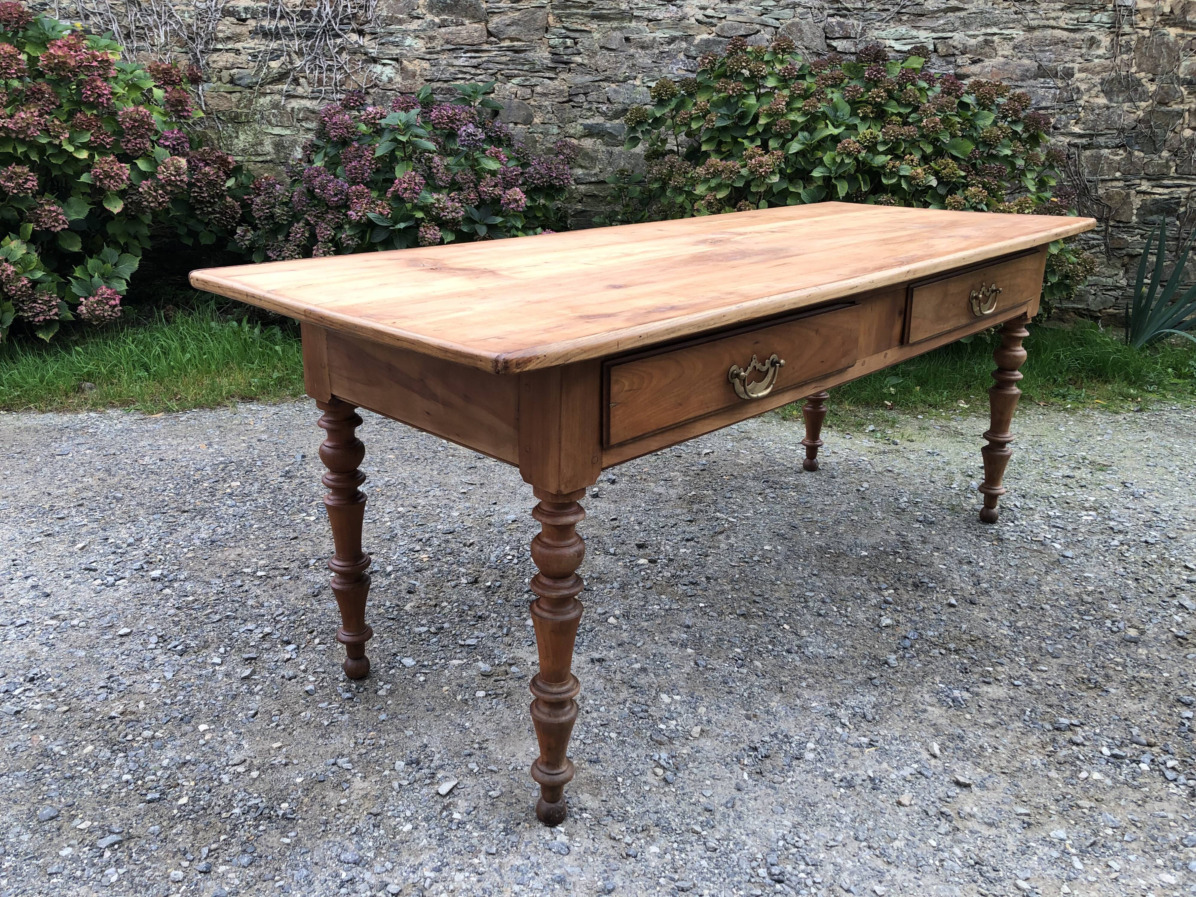 Antique Louis Philippe style farm table in solid cherry wood with 2 drawers and turned base.