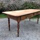 Antique Louis Philippe style farm table in solid cherry wood with 2 drawers and turned base.