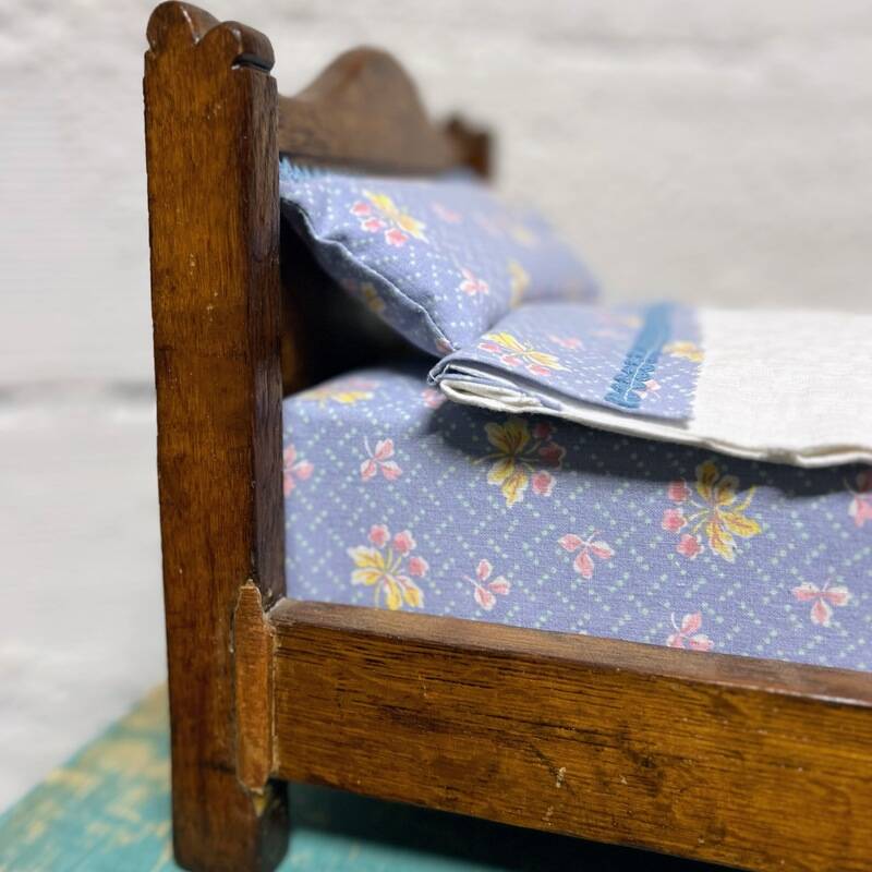 Old doll's bed in varnished wood