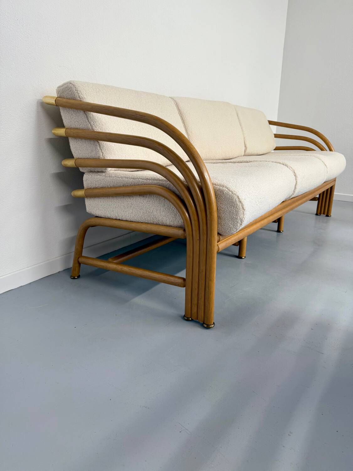 Complete living room with rattan sofa and white bouclette, brass finish, 80's design
