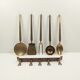 5 kitchen utensils and a brass wall mount