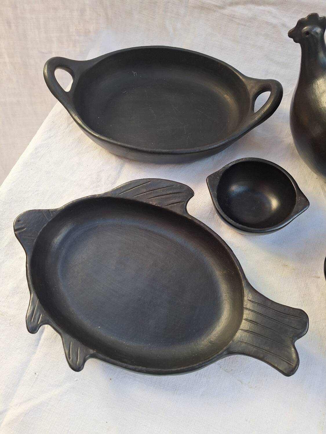 Black terracotta dinnerware set from La Chamba in Colombia. Set of 13 pieces.