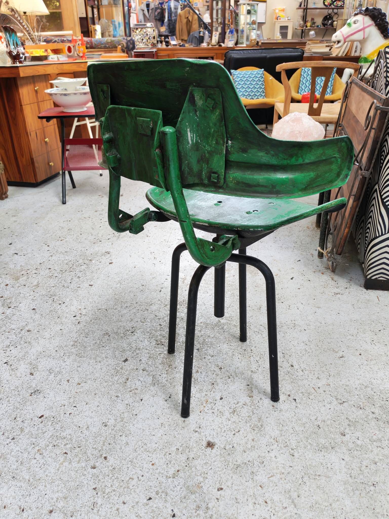 Vintage swivel workshop chair in green pressed sheet metal with a folding backrest.