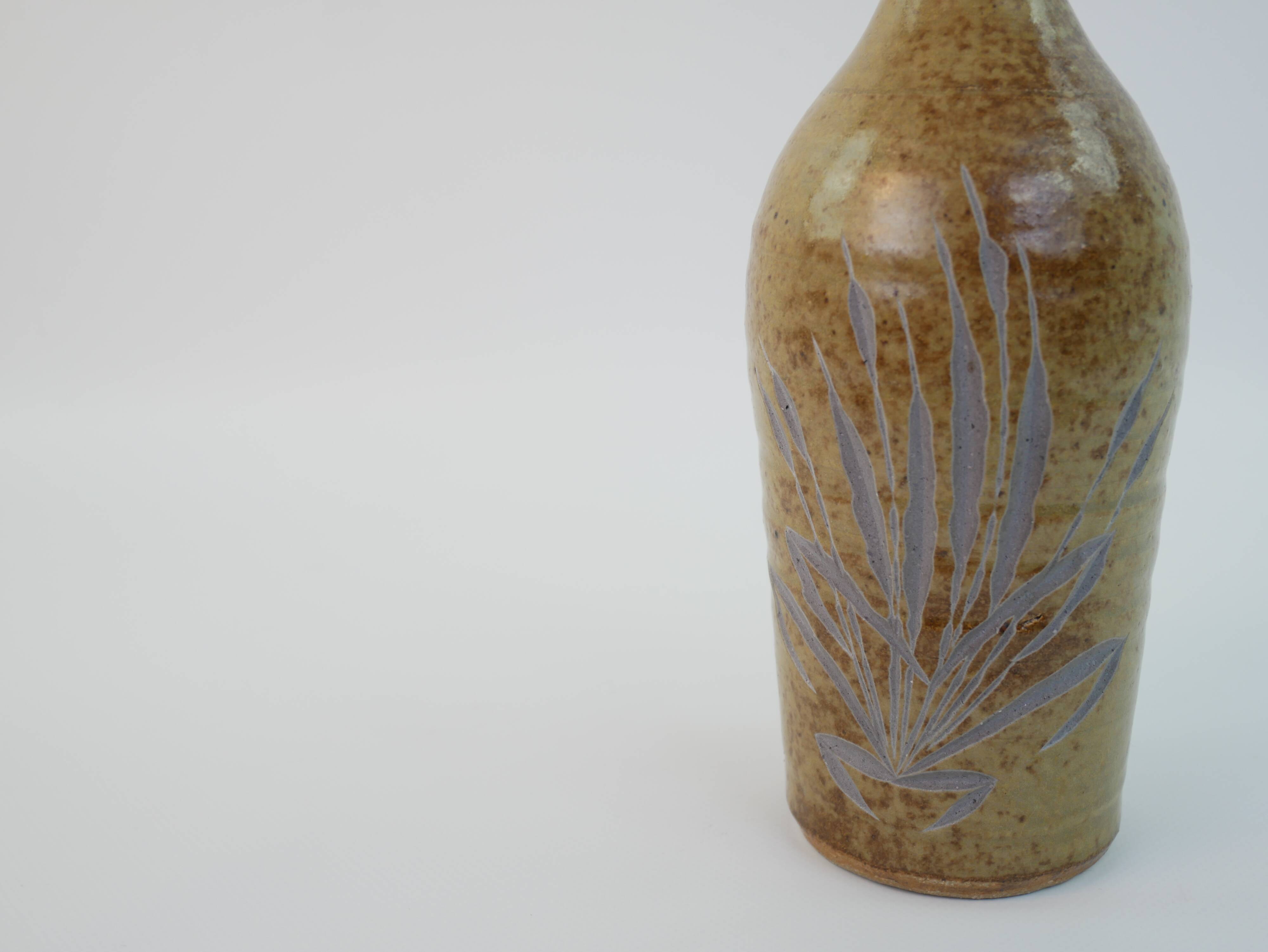 Brown ceramic/stoneware bottle with chiseled floral pattern