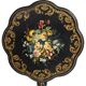 Blackened wooden side table decorated with a painted bouquet of flowers.