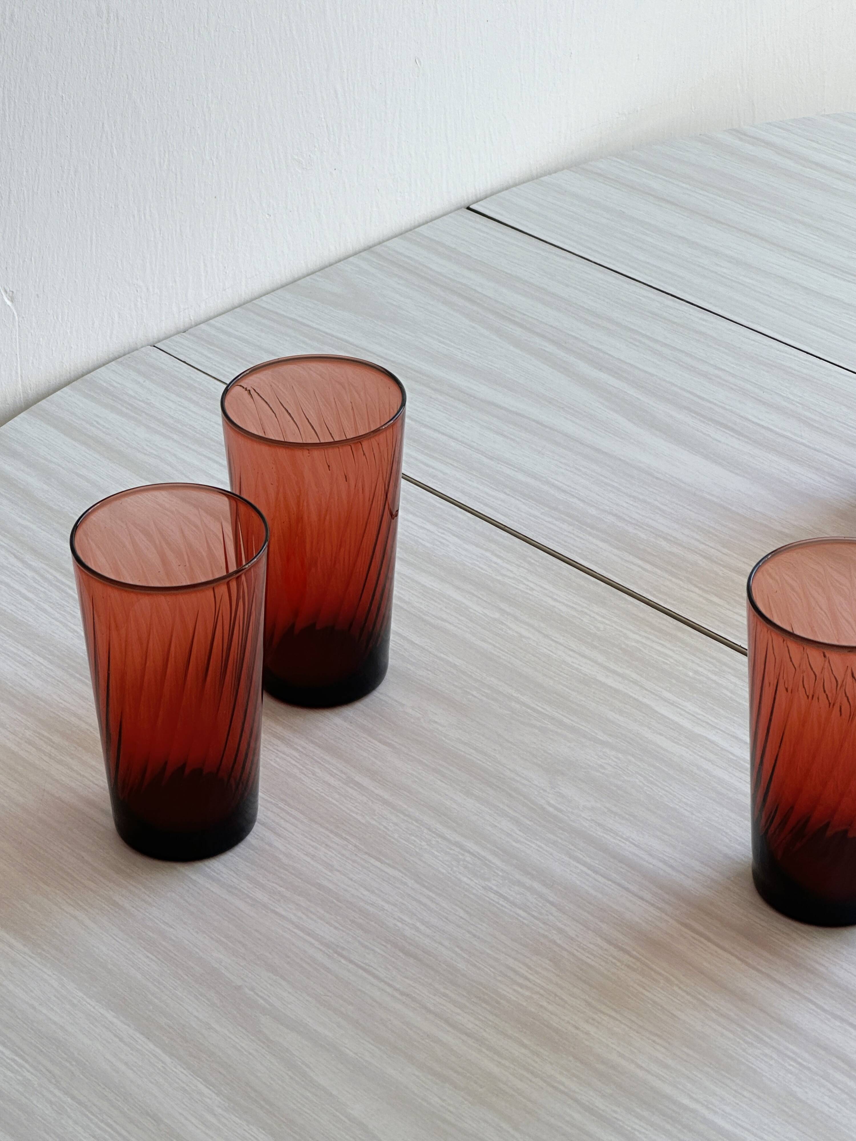4 verres à eau rouges translucides.