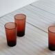 4 verres à eau rouges translucides.
