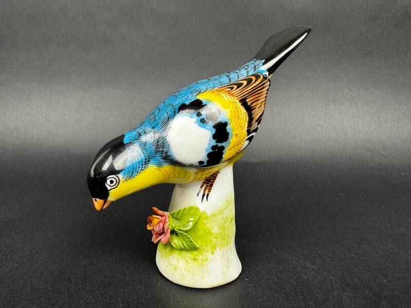 Porcelain figurine of a polychrome bird on a vintage floral base