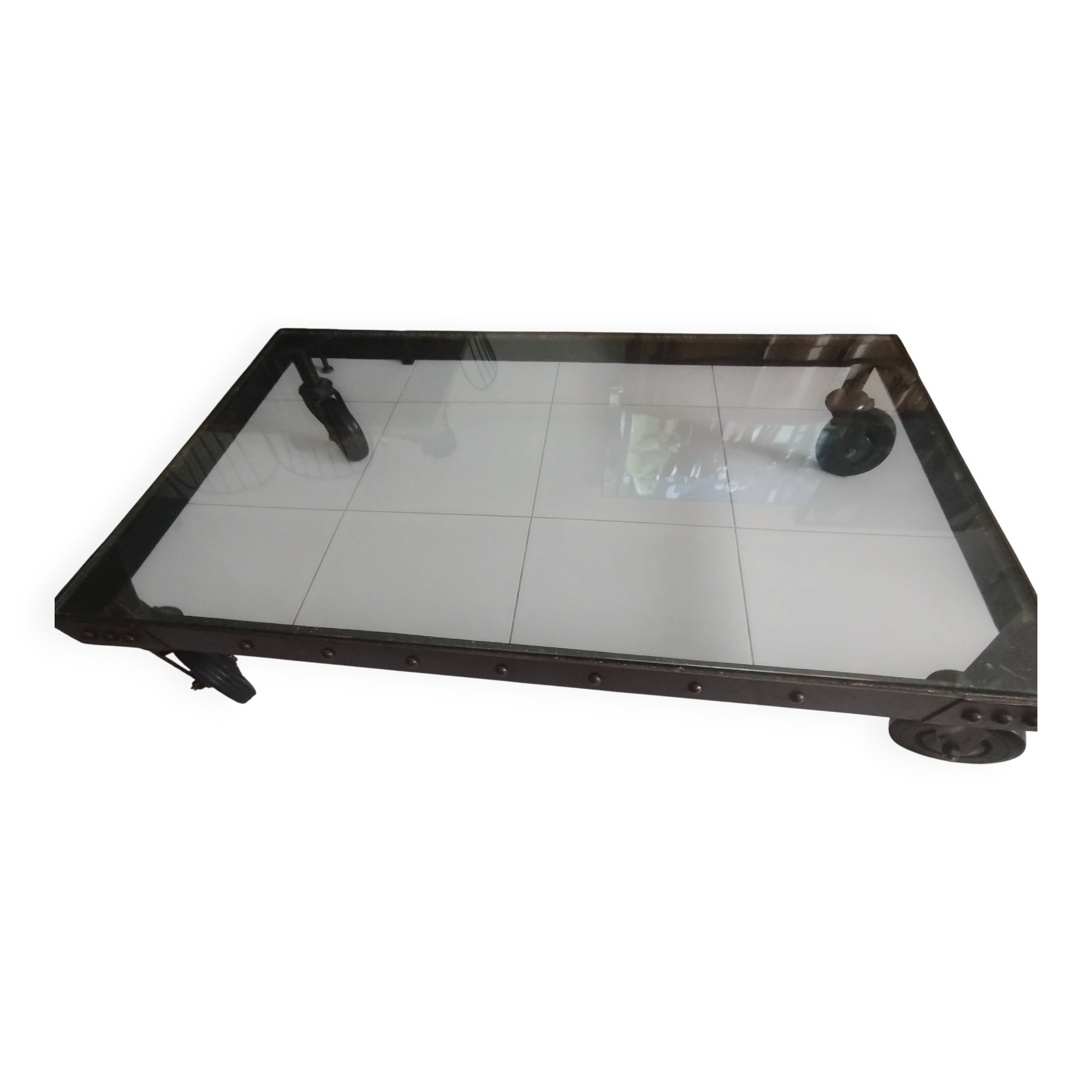 Industrial coffee table in solid metal with a glass top.