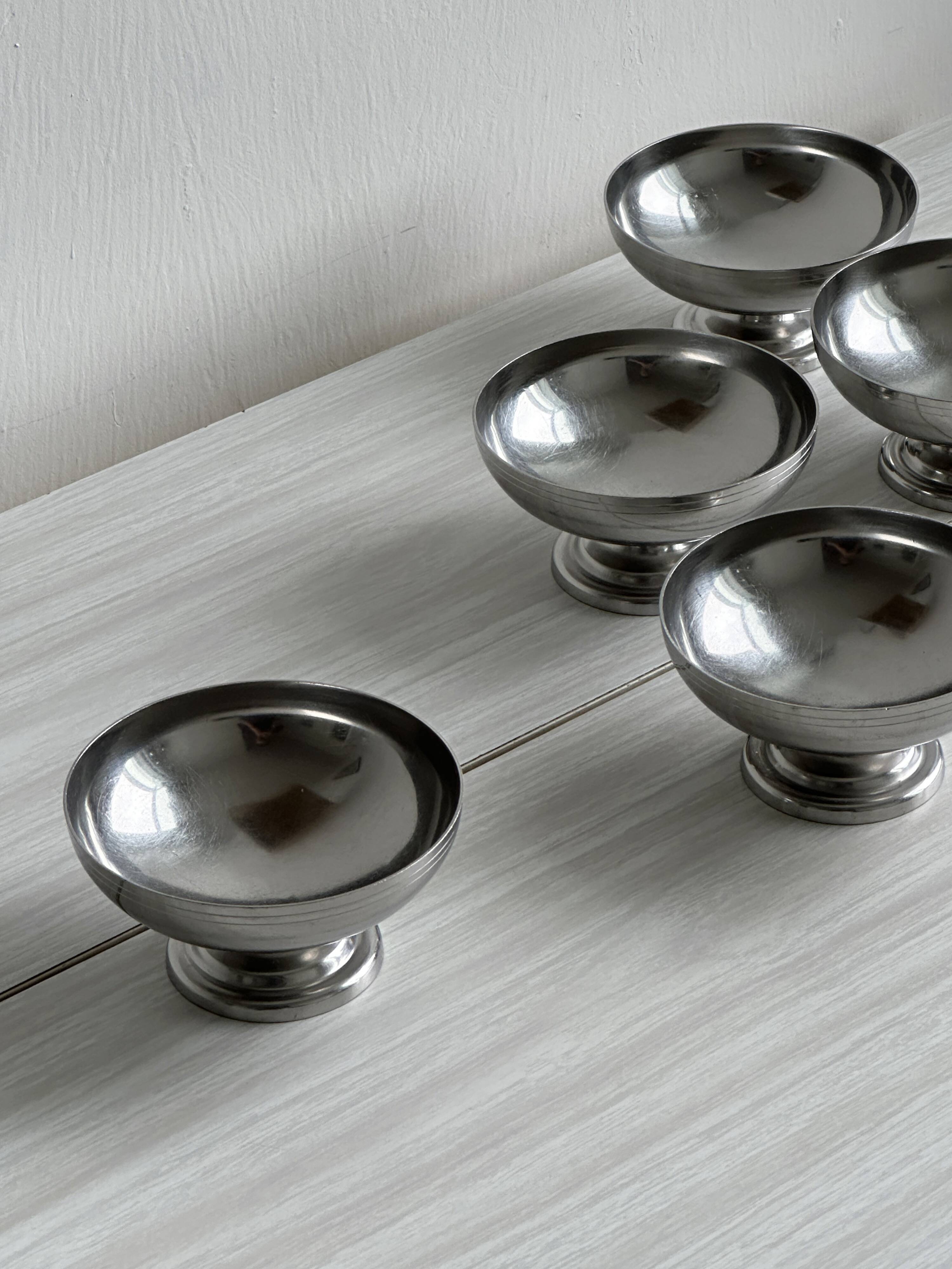 5 silver metal cups.