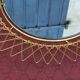 Vintage 1950s sun mirror in gold metal.